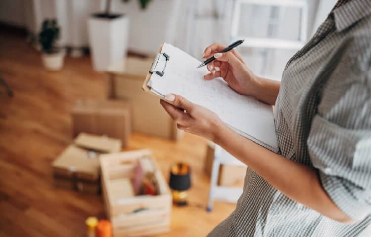 A person using a marking off items on a moving checklist.