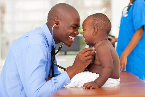 african male doctor examining baby boy