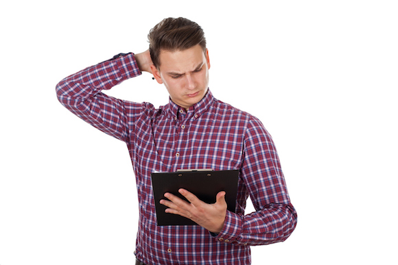Confused young guy reading a document